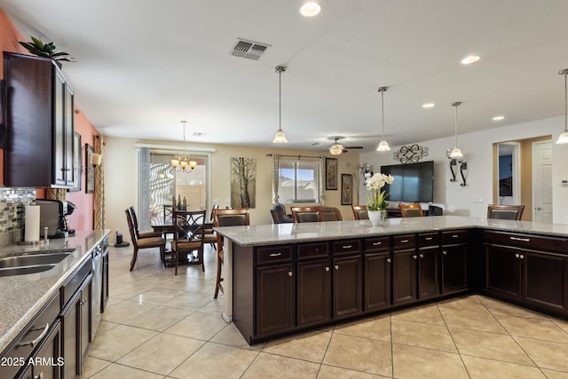 676 N 156th Ln, Goodyear, AZ 85338 - kitchen with a kitchen bar, open floor plan, decorative backsplash, and decorative light fixtures