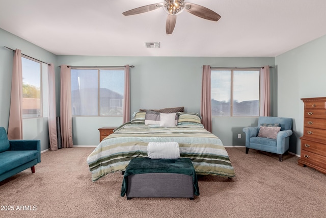 carpeted bedroom featuring multiple windows and ceiling fan