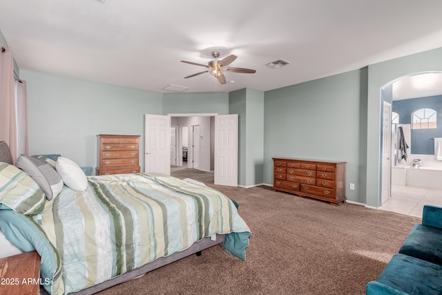 carpeted bedroom with ceiling fan and ensuite bath