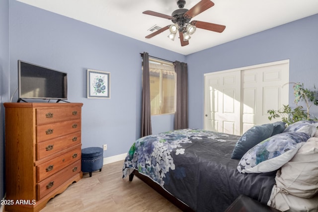 bedroom with ceiling fan, light hardwood / wood-style floors, and a closet