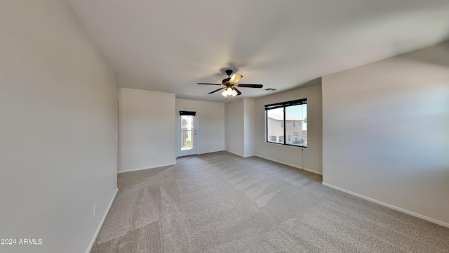 spare room with ceiling fan, plenty of natural light, and light colored carpet