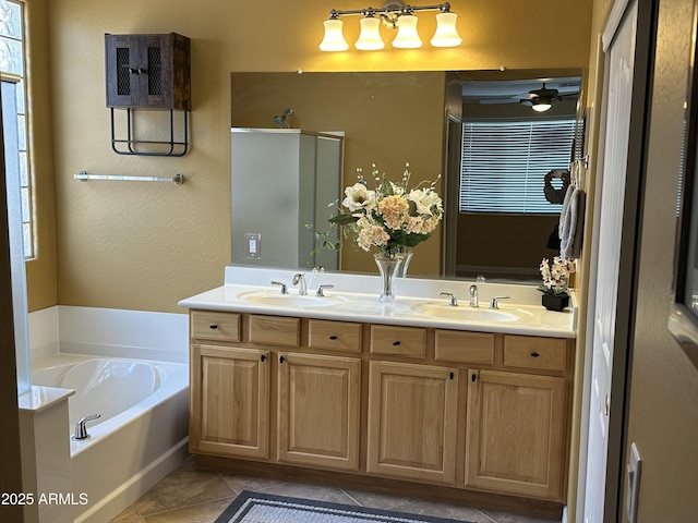 bathroom with double vanity, a stall shower, a garden tub, and a sink