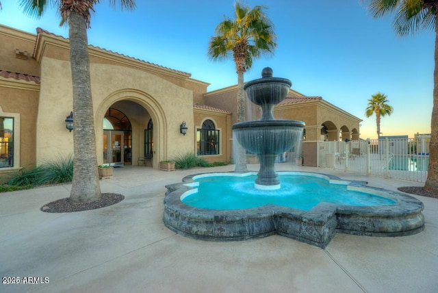 exterior space with fence and a pool with connected hot tub