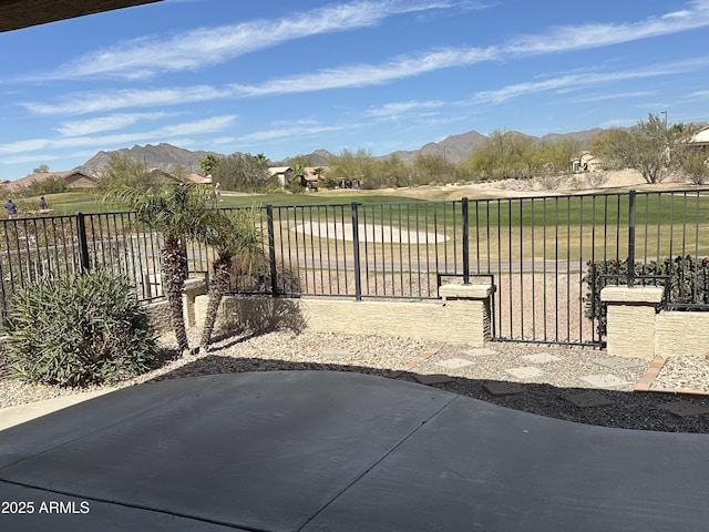 view of gate featuring a lawn, fence, and a mountain view