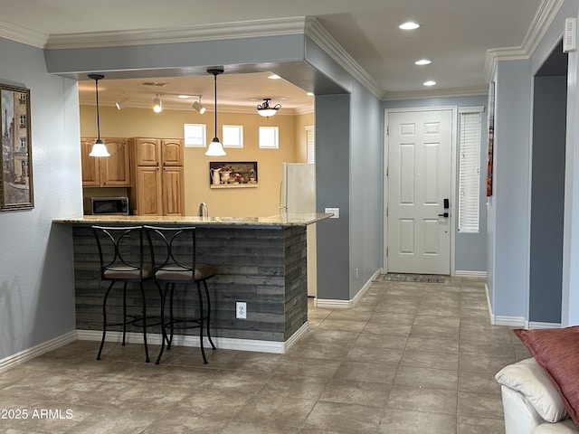 bar with stainless steel microwave, hanging light fixtures, ornamental molding, freestanding refrigerator, and baseboards