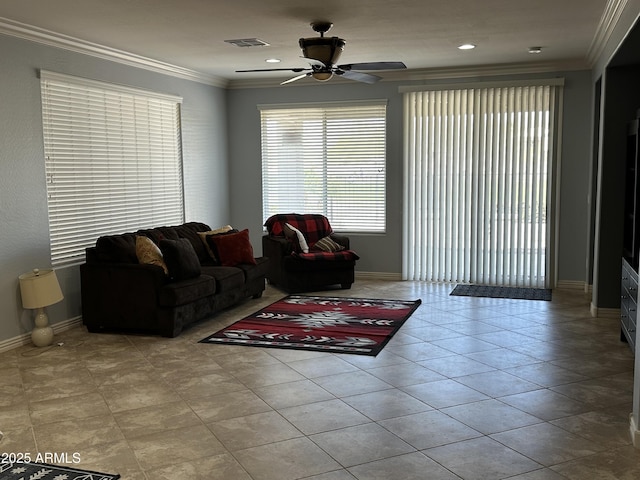 living room featuring visible vents, crown molding, baseboards, and ceiling fan