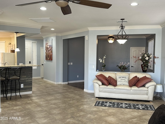 living area with baseboards, a ceiling fan, and crown molding