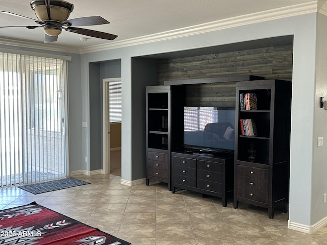 living area with crown molding, baseboards, and ceiling fan