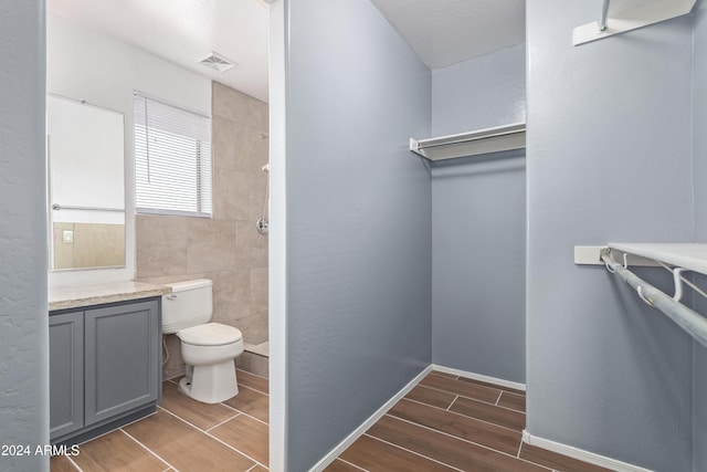 bathroom featuring vanity, toilet, and walk in shower