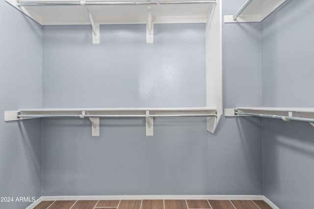 walk in closet with wood-type flooring