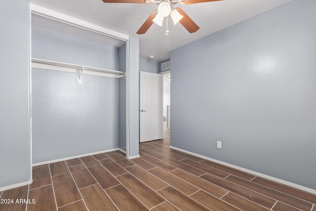 unfurnished bedroom featuring dark hardwood / wood-style flooring, a closet, and ceiling fan