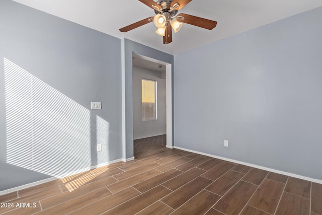 spare room featuring ceiling fan and dark wood-type flooring