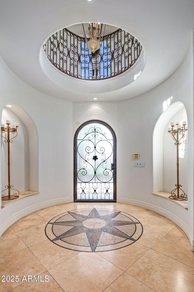 entryway with a towering ceiling and a chandelier