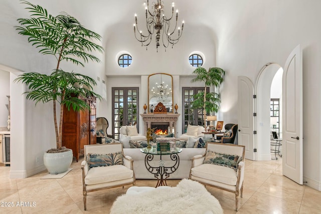 living room with a notable chandelier, a towering ceiling, beverage cooler, and french doors