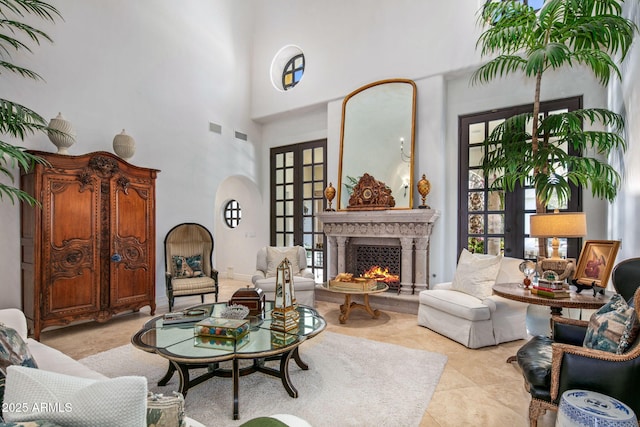 sitting room with a high ceiling, light tile patterned flooring, and french doors