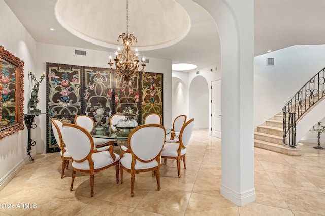 dining room featuring a raised ceiling, light tile patterned floors, and an inviting chandelier