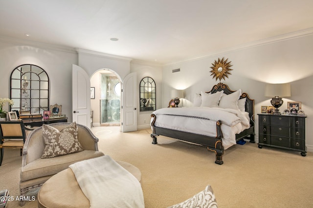 carpeted bedroom with crown molding and ensuite bath