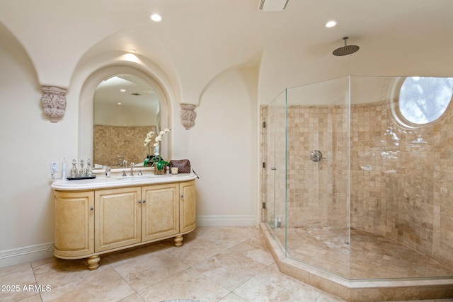 bathroom featuring tiled shower and vanity