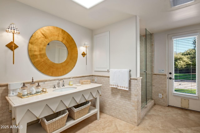 bathroom with tiled shower, tile patterned floors, tile walls, and vanity