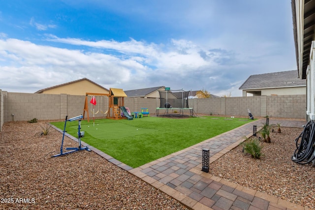 view of yard featuring a playground and a trampoline