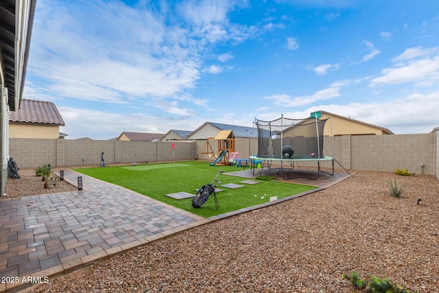 view of yard featuring a trampoline, a patio, and a playground