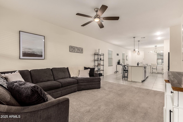 carpeted living room with sink and ceiling fan