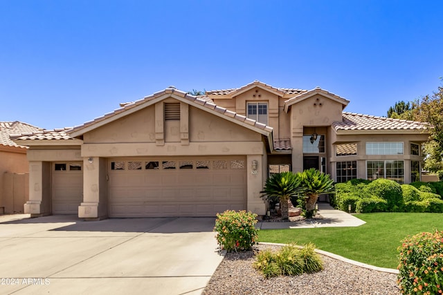 mediterranean / spanish house with a garage and a front lawn