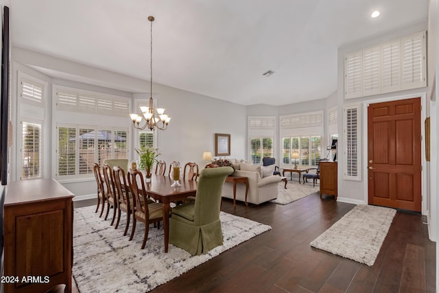 dining area with dark hardwood / wood-style flooring and a notable chandelier