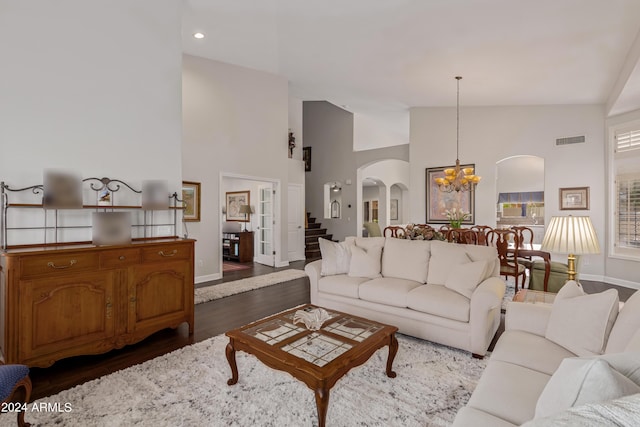 living room featuring an inviting chandelier, dark hardwood / wood-style flooring, and high vaulted ceiling