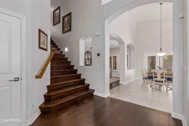 stairs with a high ceiling and wood-type flooring