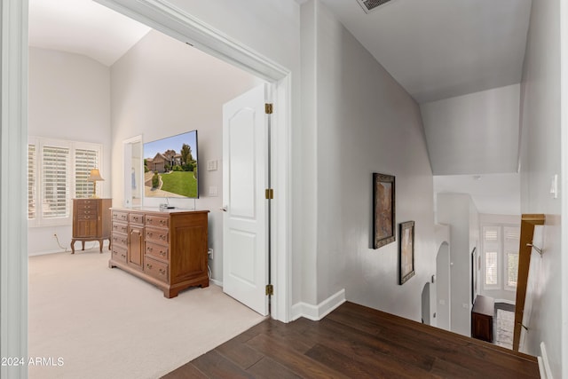 corridor featuring lofted ceiling and carpet