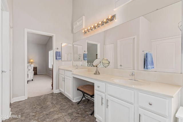 bathroom with vanity and a towering ceiling