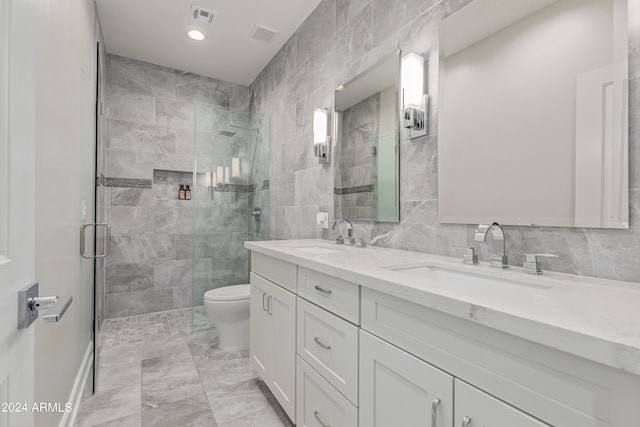 bathroom with walk in shower, vanity, toilet, and tile walls