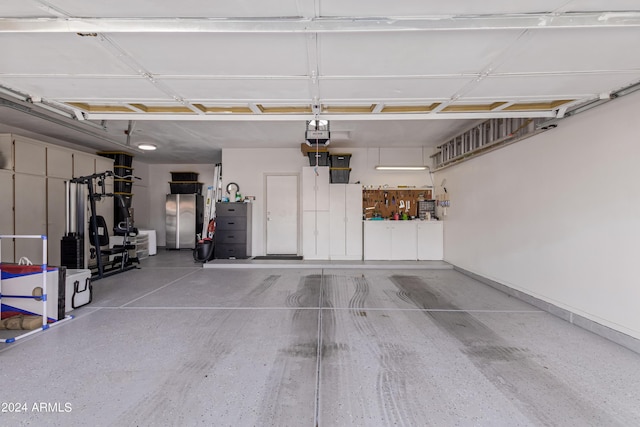 garage featuring a garage door opener and stainless steel fridge