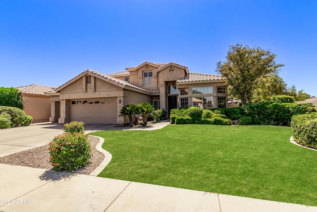 mediterranean / spanish house featuring a garage and a front lawn