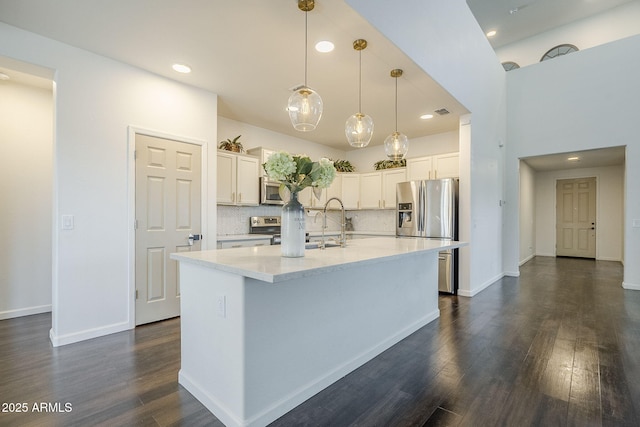 10925 E Toluca Ave, Mesa, AZ 85212 - kitchen featuring appliances with stainless steel finishes, dark wood-style flooring, white cabinetry, a kitchen island with sink, and pendant lighting