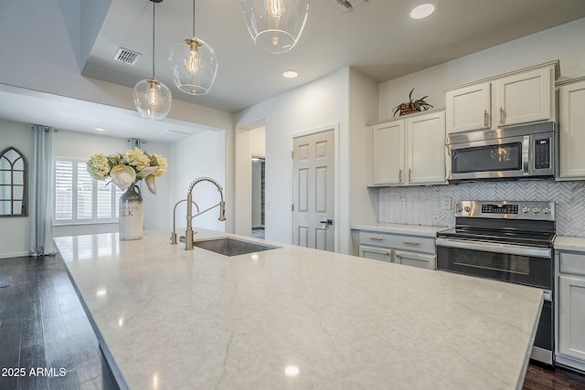 10925 E Toluca Ave, Mesa, AZ 85212 - kitchen with stainless steel appliances, a sink, backsplash, light stone countertops, and recessed lighting