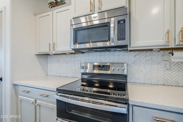 10925 E Toluca Ave, Mesa, AZ 85212 - kitchen with stainless steel appliances, tasteful backsplash, light stone counters, and white cabinets