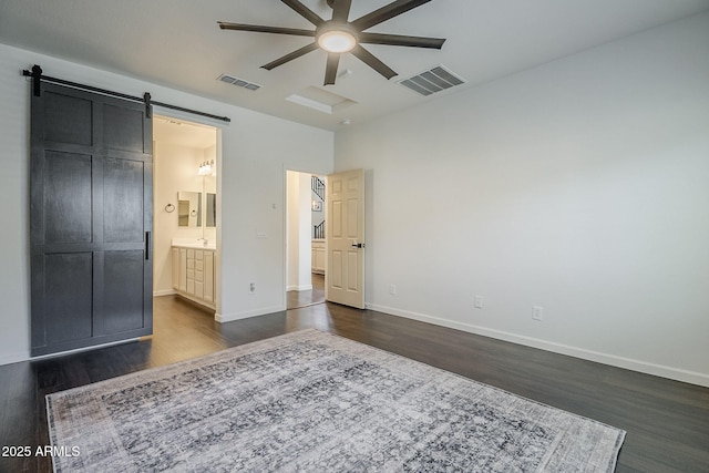 10925 E Toluca Ave, Mesa, AZ 85212 - unfurnished bedroom featuring dark wood-type flooring, a barn door, baseboards, and ensuite bathroom
