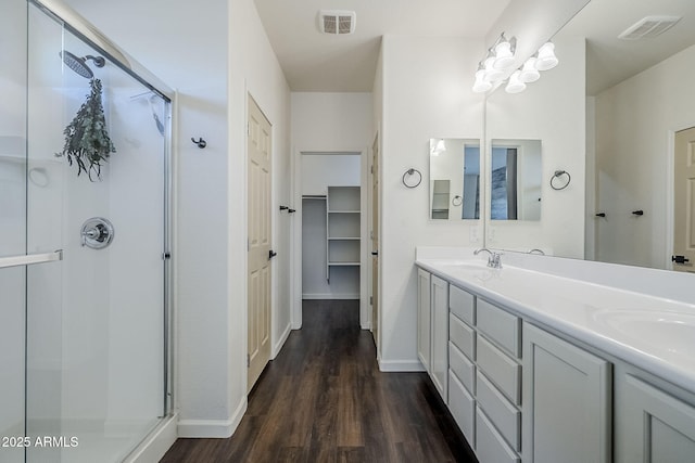 10925 E Toluca Ave, Mesa, AZ 85212 - bathroom with wood finished floors, a shower stall, baseboards, double vanity, and a spacious closet