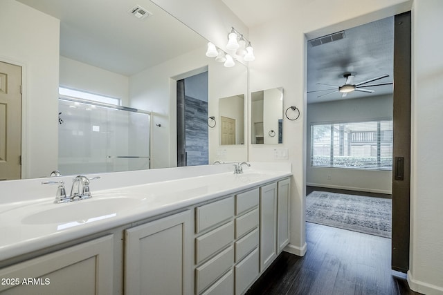 10925 E Toluca Ave, Mesa, AZ 85212 - full bathroom featuring wood finished floors, a shower stall, ceiling fan, double vanity, and baseboards