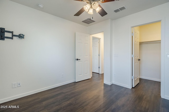 10925 E Toluca Ave, Mesa, AZ 85212 - unfurnished bedroom featuring dark wood-type flooring, a walk in closet, baseboards, and a ceiling fan