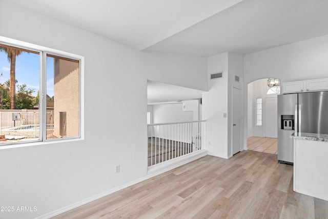 1203 W Escuda Rd, Phoenix, AZ 85027 - empty room with light wood finished floors, healthy amount of natural light, a chandelier, and arched walkways