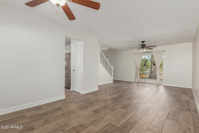 3805 E Desert Flower Ln, Phoenix, AZ 85044 - unfurnished living room with a ceiling fan, stairway, wood finished floors, and baseboards