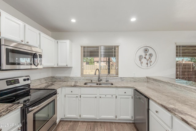 3805 E Desert Flower Ln, Phoenix, AZ 85044 - kitchen featuring appliances with stainless steel finishes, a sink, light stone counters, white cabinets, and healthy amount of natural light