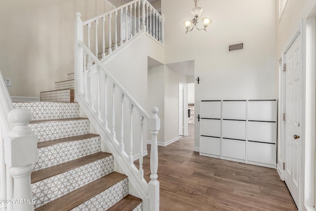3805 E Desert Flower Ln, Phoenix, AZ 85044 - staircase with wood finished floors, a high ceiling, a chandelier, and baseboards