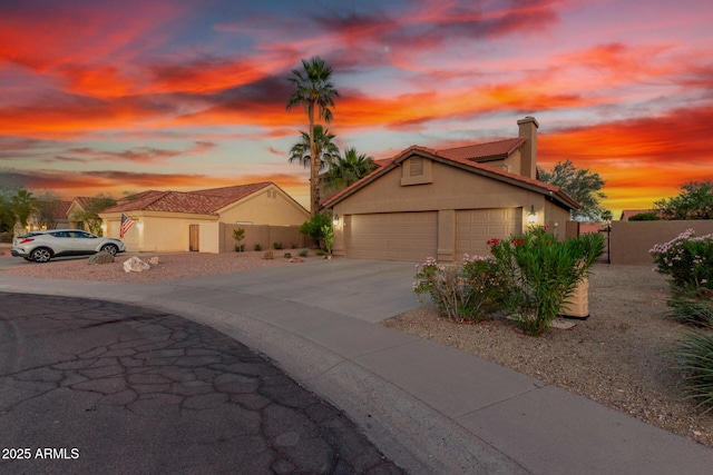 3805 E Desert Flower Ln, Phoenix, AZ 85044 - view of front facade with a chimney, concrete driveway, fence, stucco siding, and a tile roof