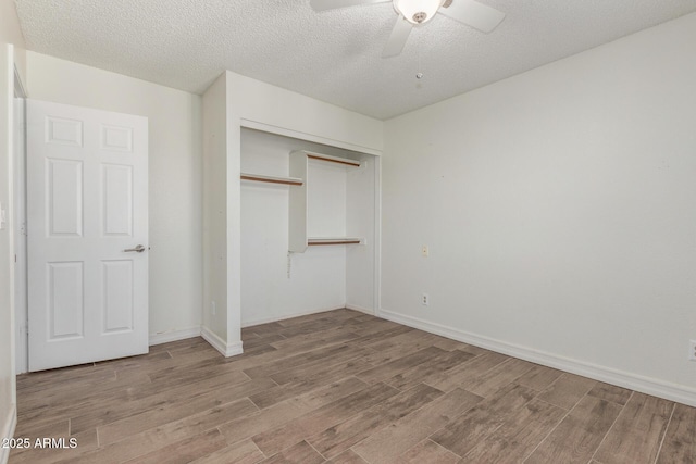 3805 E Desert Flower Ln, Phoenix, AZ 85044 - unfurnished bedroom with wood finished floors, a closet, a ceiling fan, a textured ceiling, and baseboards