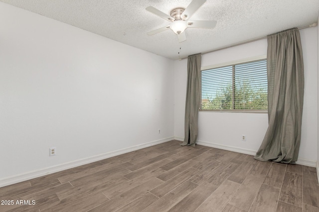 3805 E Desert Flower Ln, Phoenix, AZ 85044 - empty room with light wood-style floors, a textured ceiling, a ceiling fan, and baseboards