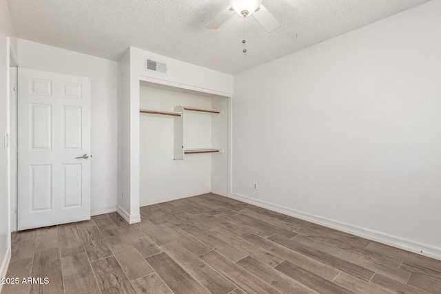 3805 E Desert Flower Ln, Phoenix, AZ 85044 - unfurnished bedroom featuring wood finished floors, a closet, a textured ceiling, a ceiling fan, and baseboards